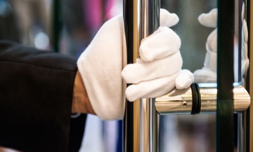 gloved hand opens glass door